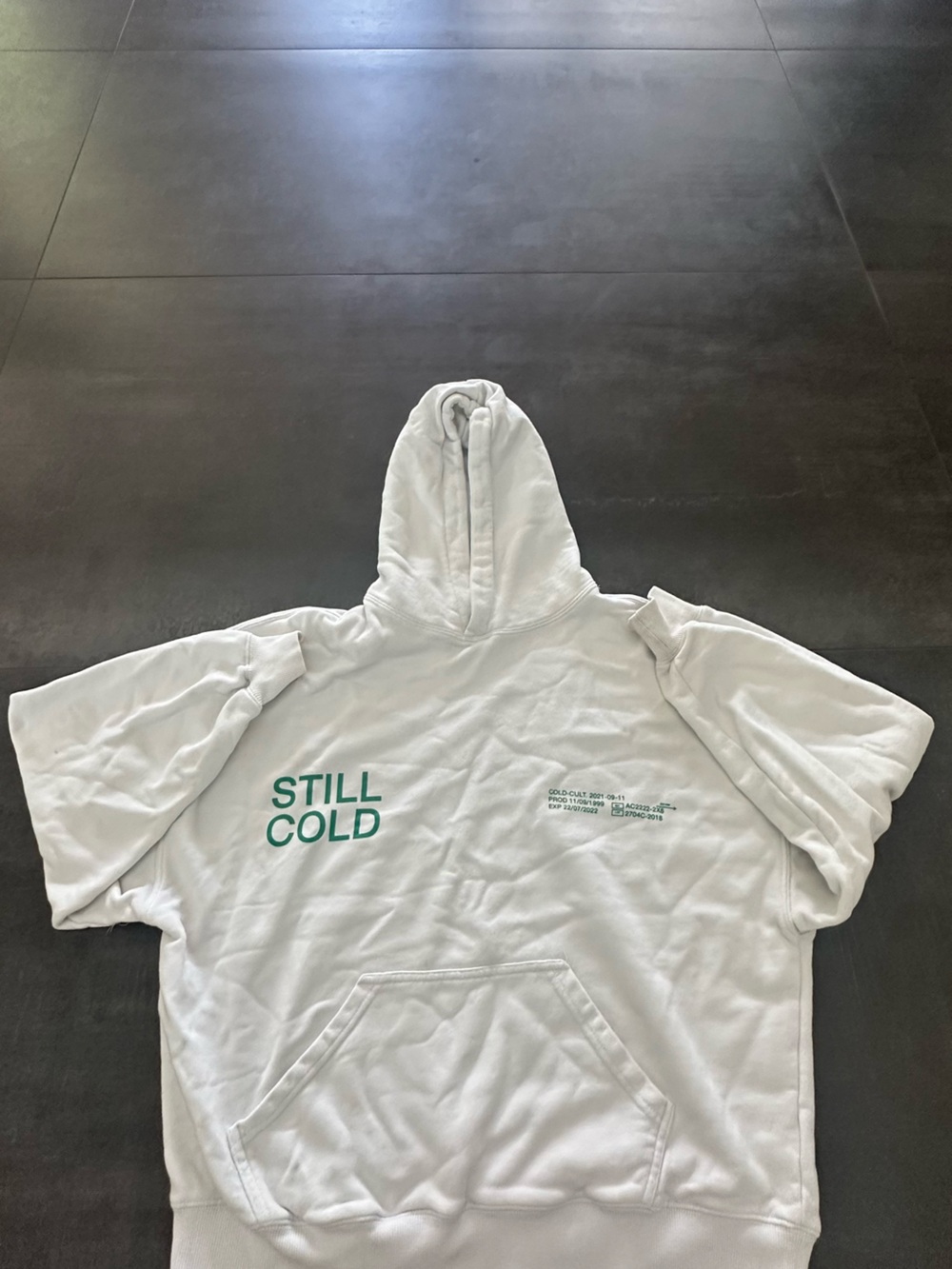 White 'STILL COLD' Graphic Hoodie with Green Print